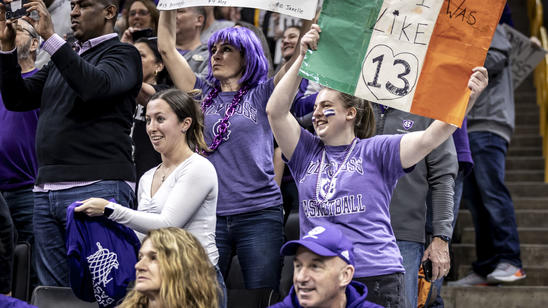 A women holds a sign that looks like the Irish flag with the number 13