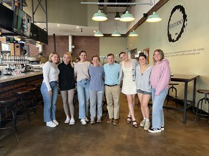 Several young women standing in a line, posing for a picture at a restaurant in Worcester