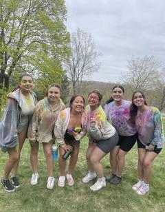 A group of young woman standing together with tie-dyed shirts