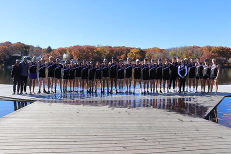 A large group of Holy Cross rowers standing in a line shoulder to shoulder