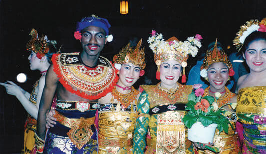 A group of people standing shoulder-to-should in Balinese regalia