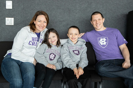 two adults and two children in Holy Cross attire