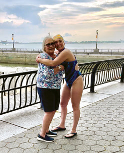 Woman in bathing suit hugs woman