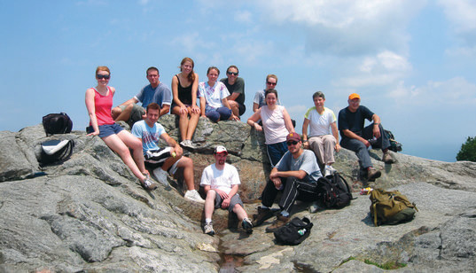 Group of people sit on a mountain peak