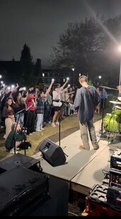 Benjamin facing a sea of flash lights as Razzberry Jam performs their first original song at Fall Band Night (2024)