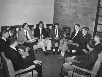 Black and white photo of students sitting in a circle