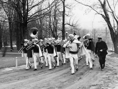 Black and white photo of band marching on the road