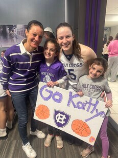 Two women and two children with a homemade sign reading "Go Kaitlyn"