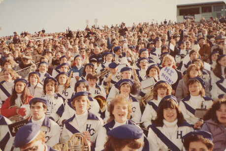 Band members smiling in the football stands