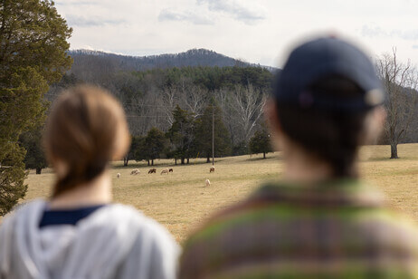 Two students look out at a farm