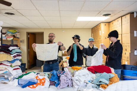 Four people folding towels