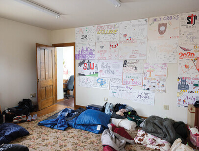 Room with handmade posters on walls and sleeping bags on the floor