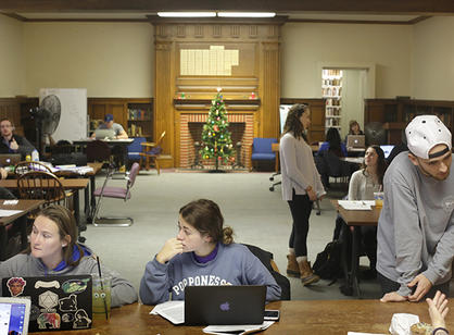 A Christmas tree keeps students company as they study in Dinand Library.