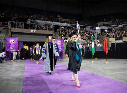 Patricia Ring, registrar, carries the college mace to lead the processional.