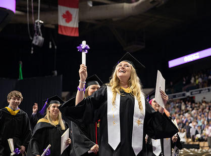 A student shares a moment with family sitting in the crowd.