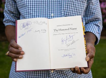 Signatures from alumni of color in De Leaver's copy of "Thy Honored Name," the College's official history written by the late Rev. Kuzniewski, S.J.