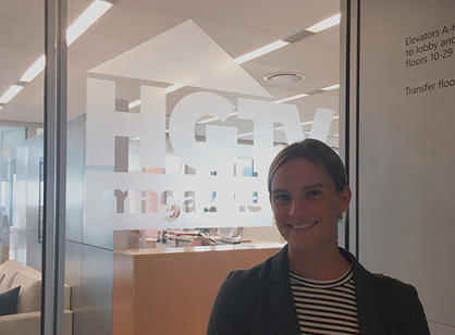 A student stands in front of a sign for HGTV Magazine
