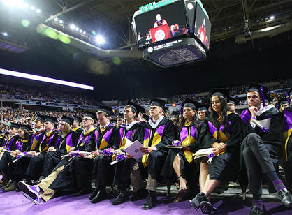 Graduates watch Rev. Philip L. Boroughs, S.J. speak.