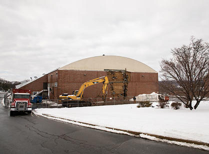 A wide angle shot of the side of the Field House with a hole in it