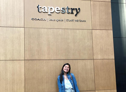 A student stands under a sign that says Tapestry