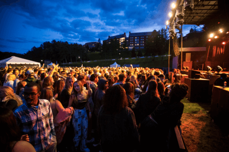 Students watch a concert in a crowd on campus.