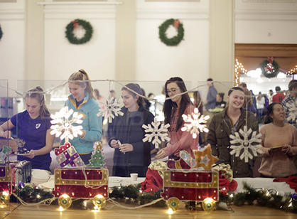 Students wait in line for dessert at the annual holiday dinner in a decorated Kimball Hall.