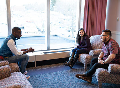 DeRay McKesson sits in a chair across from Mithra Salmassi '19 and Manny Trejo '19