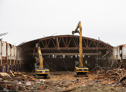 Two large pieces of construction machinery tear into the Field House