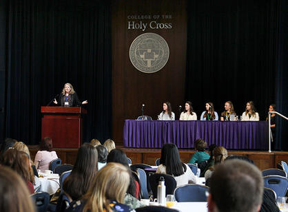 A speaker stands on stage in front of a crowd