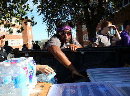 a student picks things out of the back of a truck