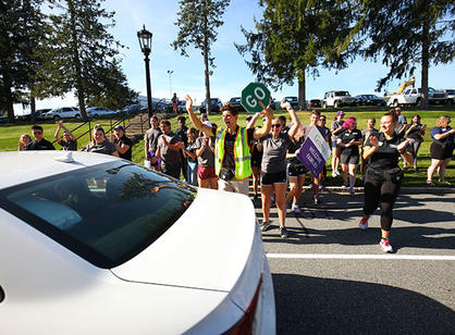 students cheer as a car drives by