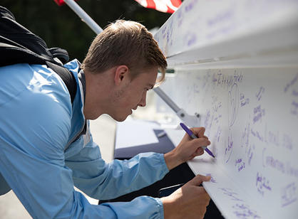 A student signs the beam