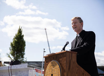 Fr. Boroughs talks at a podium