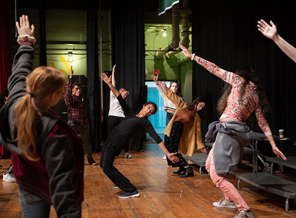 Students stretch on stage