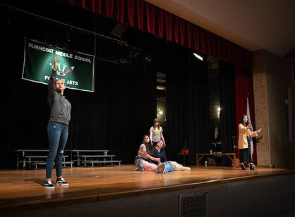 Students act out a scene on stage