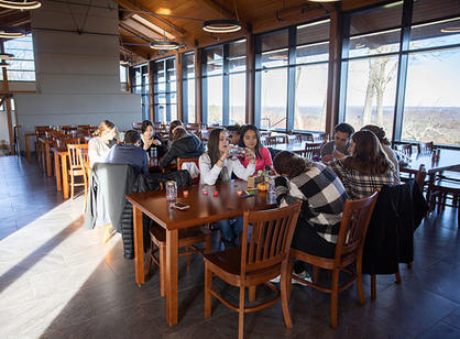 A group of students sit at a table and do arts and crafts
