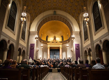 A wide-angle shot of St. Joseph Memorial Chapel with music being performed in the front