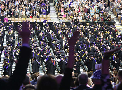 Friends and family wave to students as they process into the DCU Center.