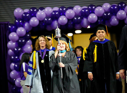 Patricia Ring, registrar, carries the college mace to lead the processional.