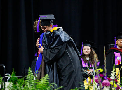 Class of 2018 dean M. Estrella Cibreiro-Couce hugs a student.