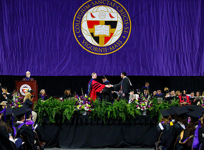 A student receives their diploma from Rev. Philip L. Boroughs, S.J., president of the College.