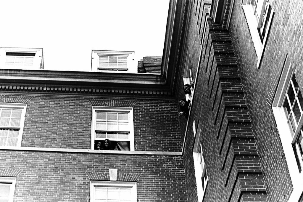 Women hang out the window of Wheeler Hall in the early 1970s. 