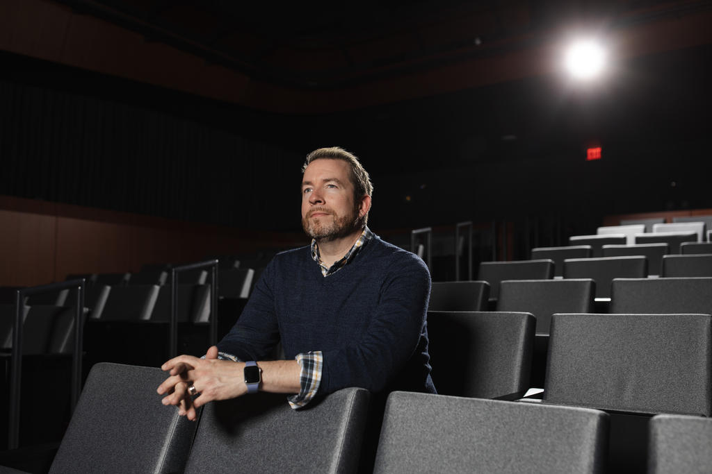 A man seated in a movie theater