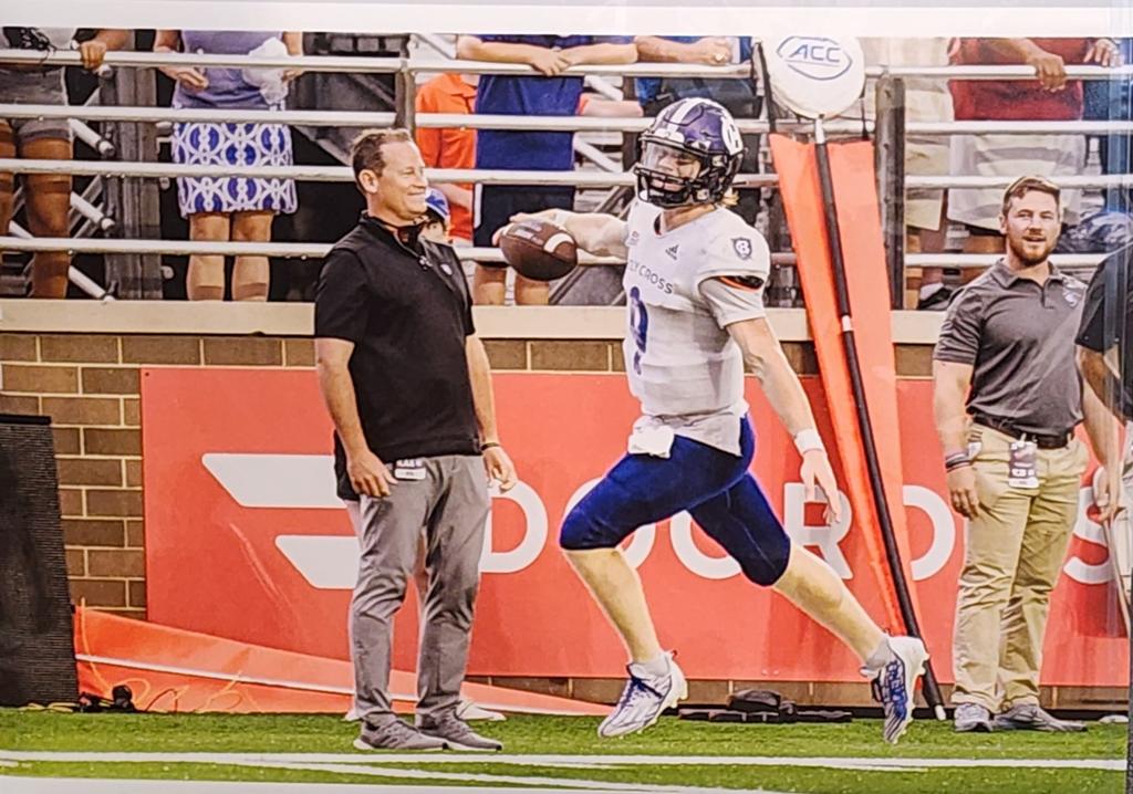A football player running by a man
