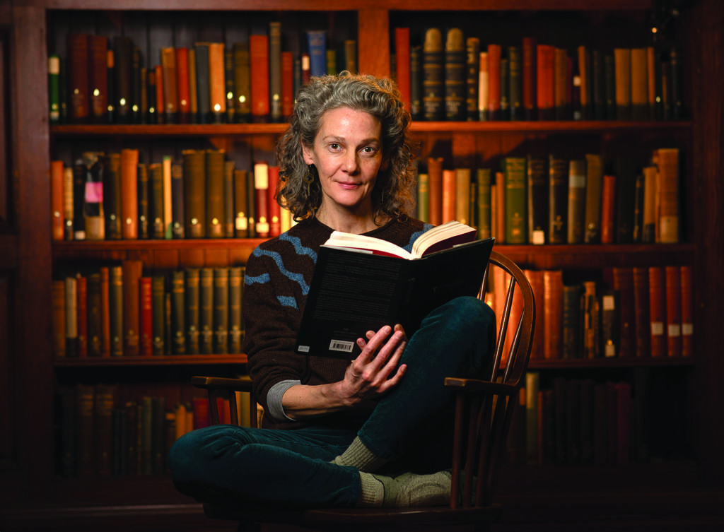 Woman sitting in chair holds an open book