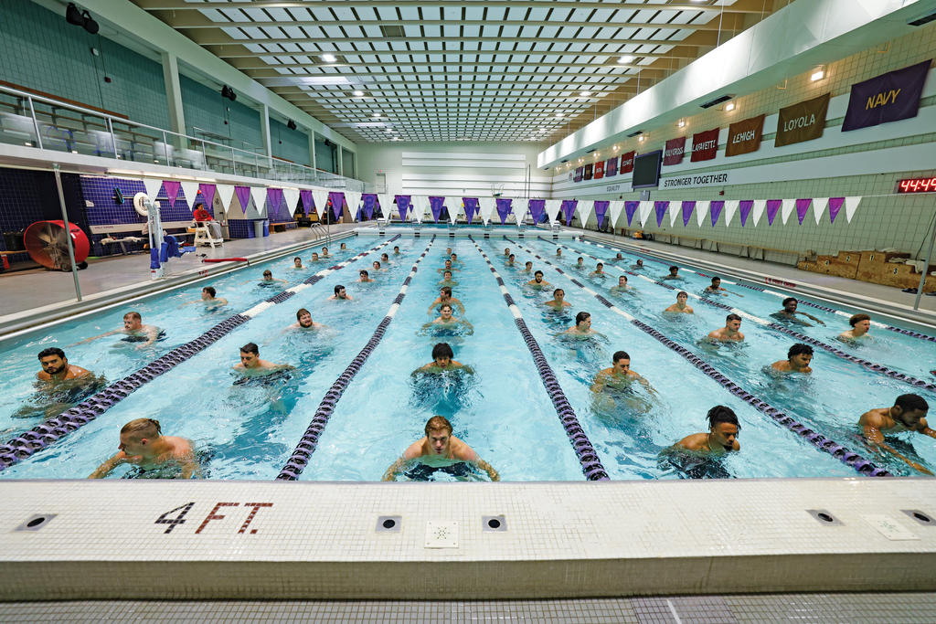 Men stand in lines in an Olympic-sized pool
