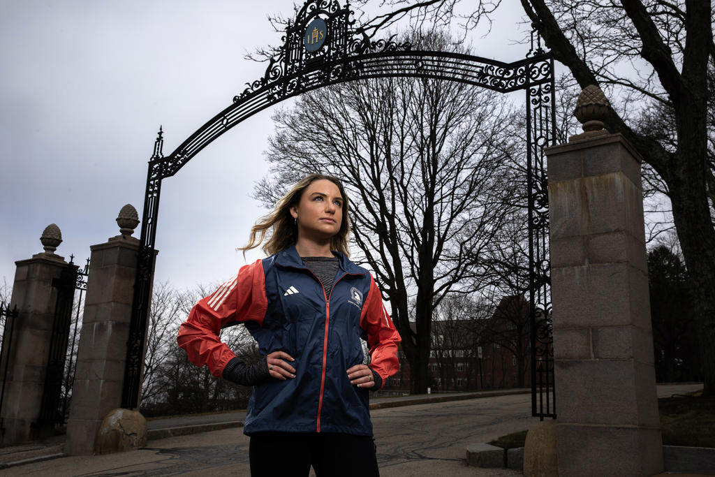 A female runner looking away with hands on her hips