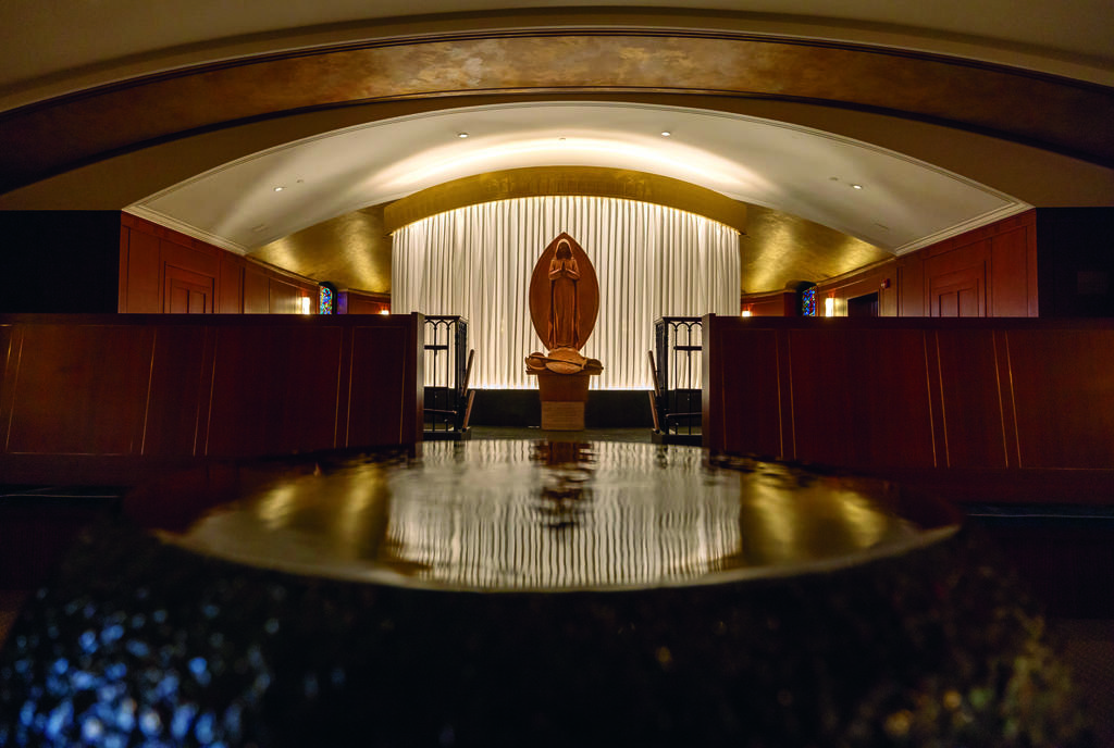 Small worship space featuring a baptismal font, chairs and an altar