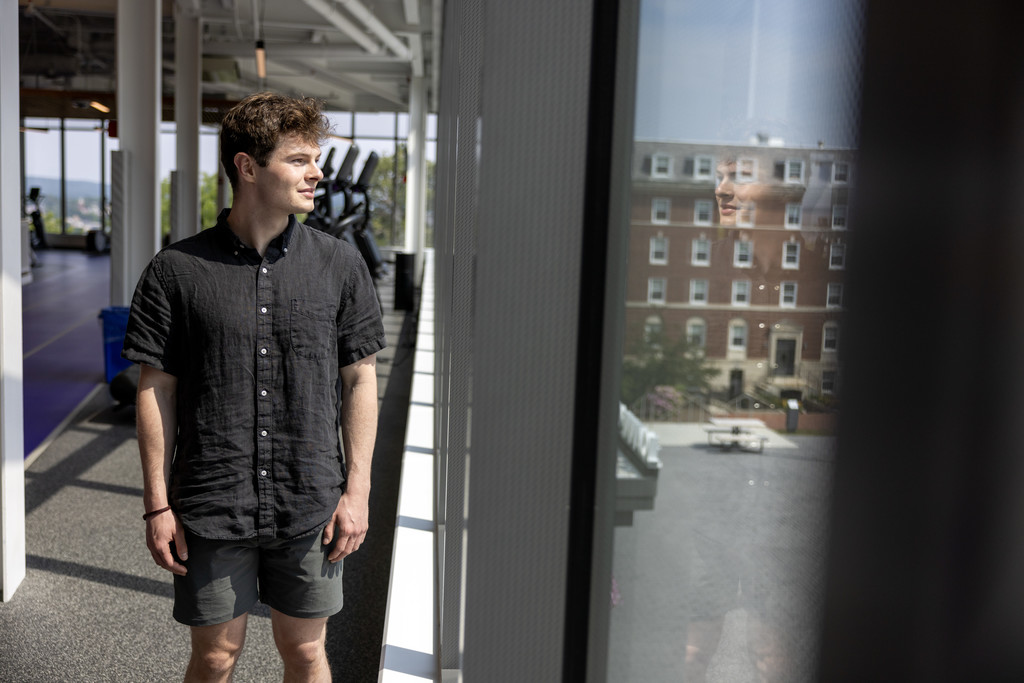 Man standing looks out window