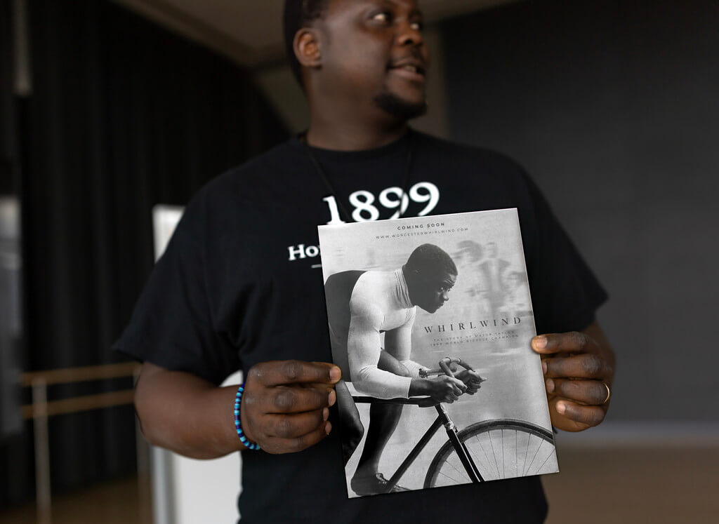 Man holds up small poster